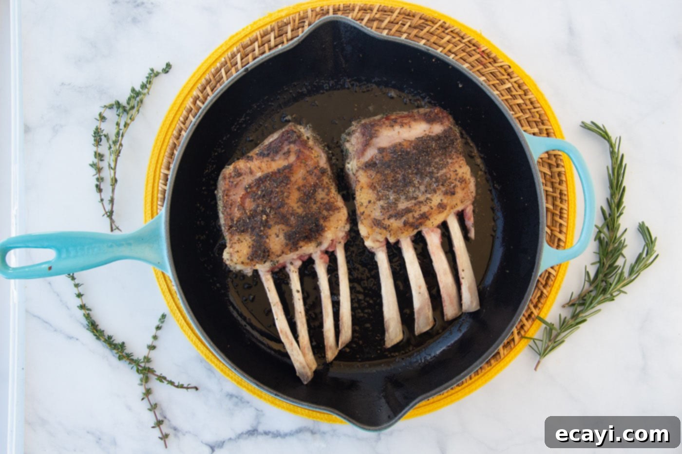 The Butcher's Crown 6 A rack of lamb searing in a hot skillet, developing a golden crust.
