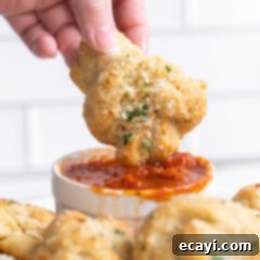 Pillowy Garlic Swirls 18 A perfectly golden and fluffy garlic knot, sprinkled with Parmesan and parsley, hinting at its soft, buttery interior.