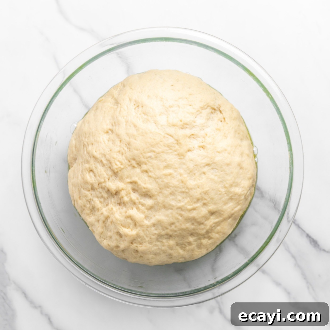Pillowy Garlic Swirls 9 A large, perfectly risen dough ball, having doubled in size, filling a mixing bowl and showcasing its airy texture.