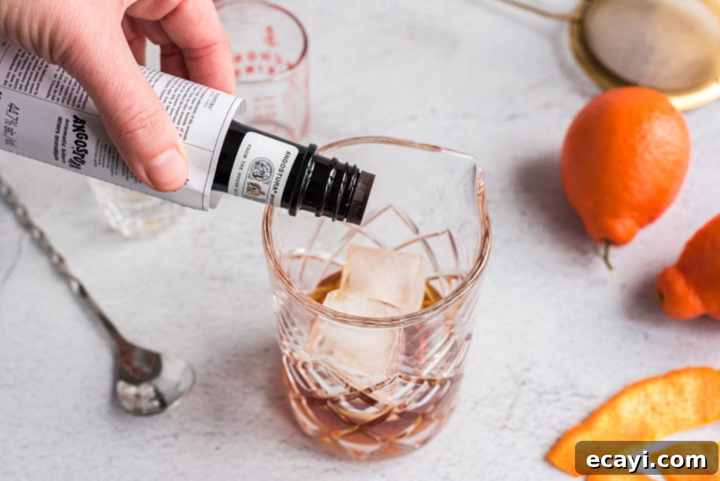 Manhattan's Signature Spirit 6 Adding dashes of Angostura bitters to the whiskey and vermouth mixture in a mixing glass.