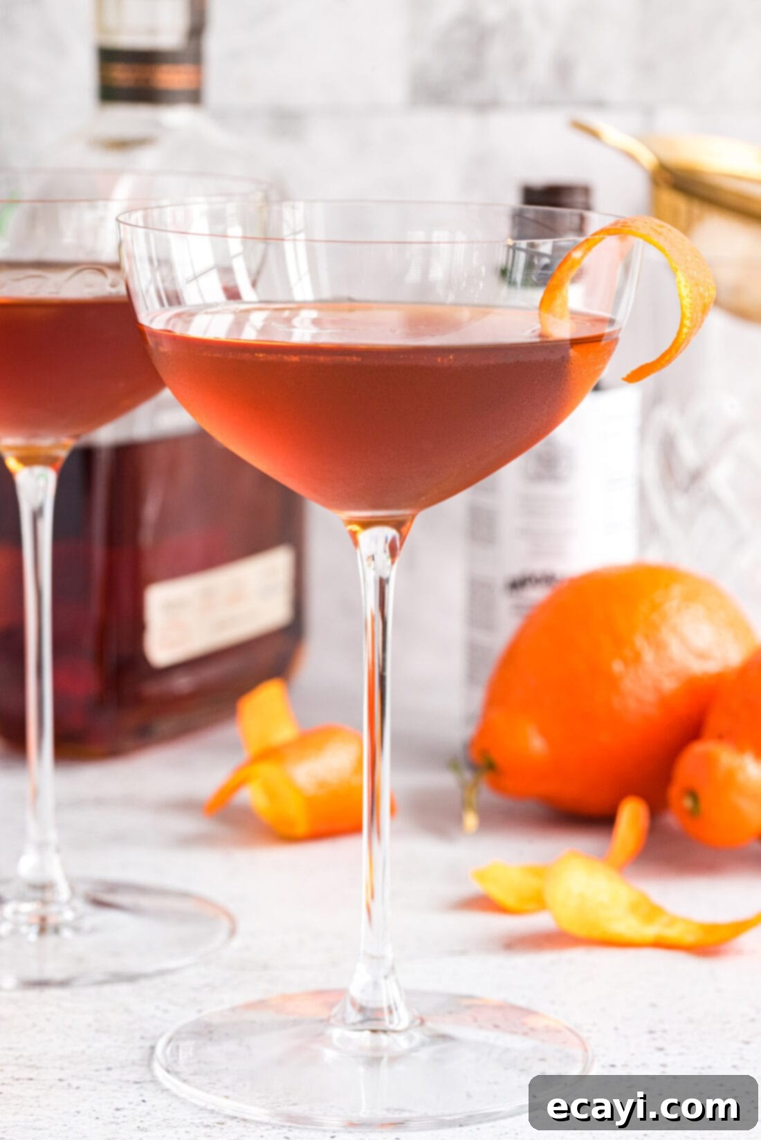 Manhattan's Signature Spirit 9 Manhattan cocktail with liquor bottles in a bar setting, ready for enjoyment.