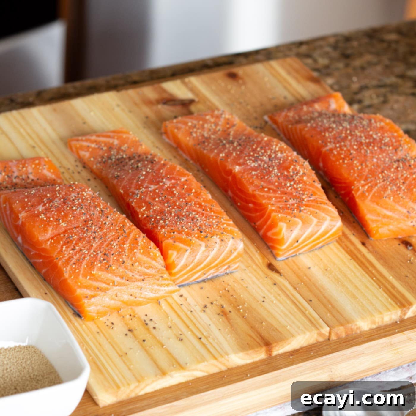 Smoky Cedar Plank Salmon 5 Seasoned salmon filets ready for the cedar plank on a cutting board, with salt and pepper