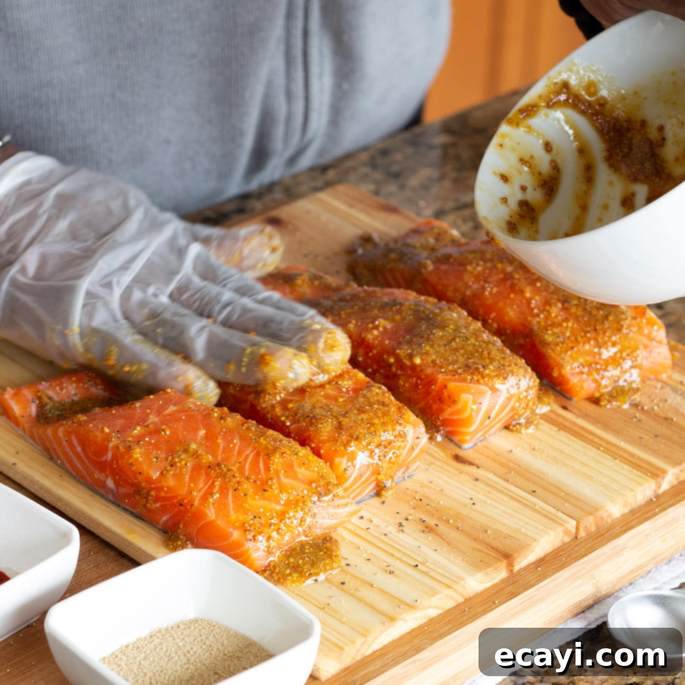 Smoky Cedar Plank Salmon 7 Applying the mustard and honey marinade onto salmon filets with a spatula