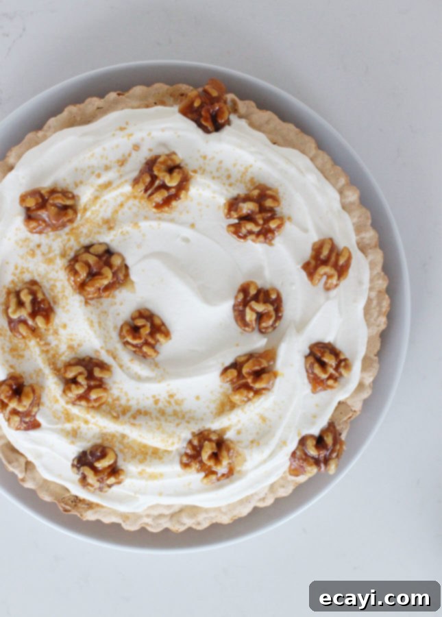 Maple Walnut Cream Tart 4 Walnut and Maple Cream Tart slice on a plate, showcasing the layers of crust, cream, and walnuts