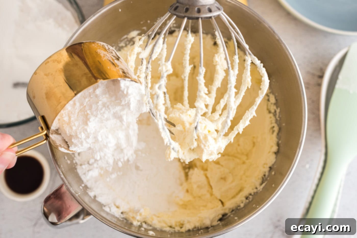 Luscious Cream Cheese Frosting 6 Adding sifted powdered sugar slowly into the creamed butter and cream cheese mixture in a stand mixer.