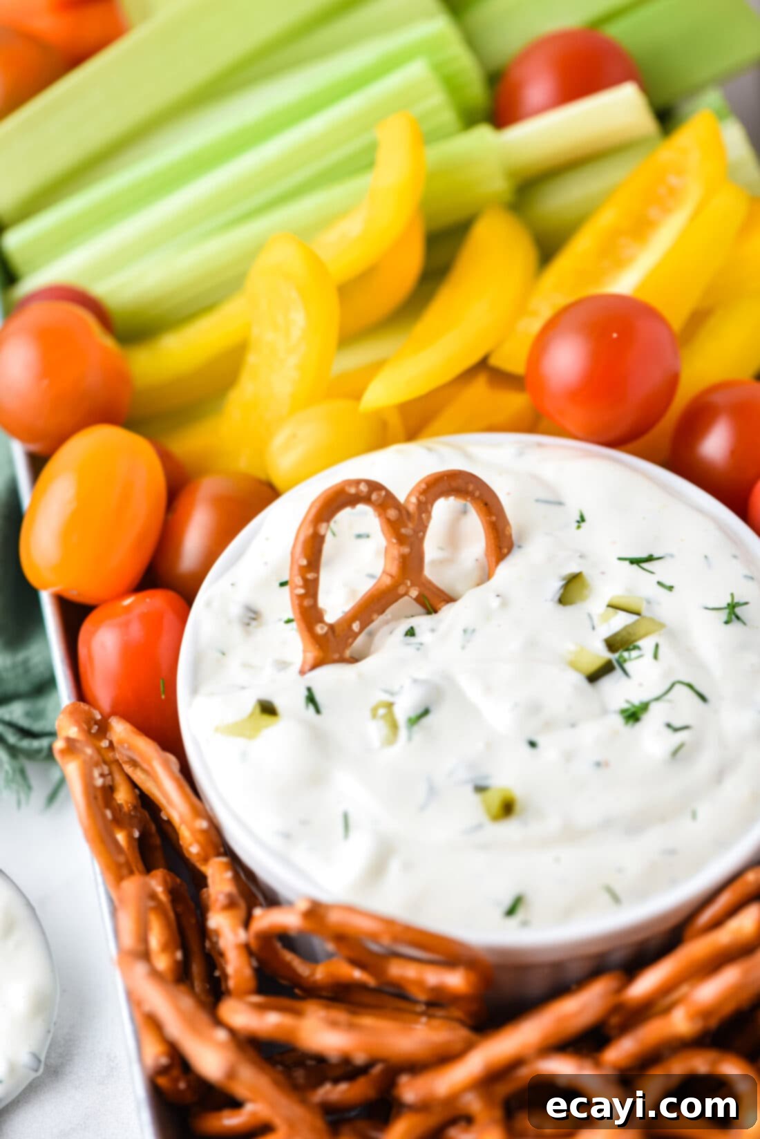 Dill Pickle Delight Dip 2 Creamy Dill Pickle Dip with a pretzel in it, ready to be served at a party