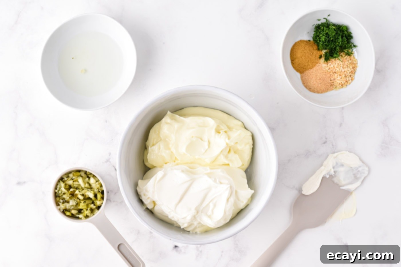 Dill Pickle Delight Dip 6 Mayonnaise and sour cream in a mixing bowl, ready for other ingredients