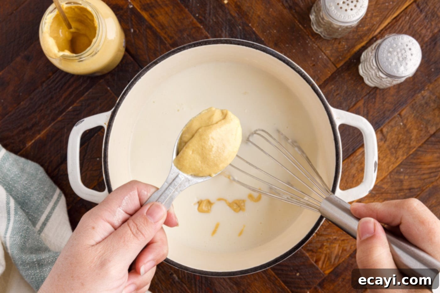 Gourmet Stuffed Chicken Rolls 13 Whisking Dijon mustard into a rich cream sauce in a saucepan