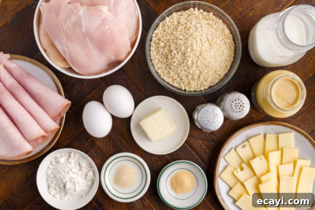 Gourmet Stuffed Chicken Rolls 4 A flat lay of fresh ingredients laid out for making chicken cordon bleu, including chicken breasts, ham, Swiss cheese, breadcrumbs, eggs, and sauce components.