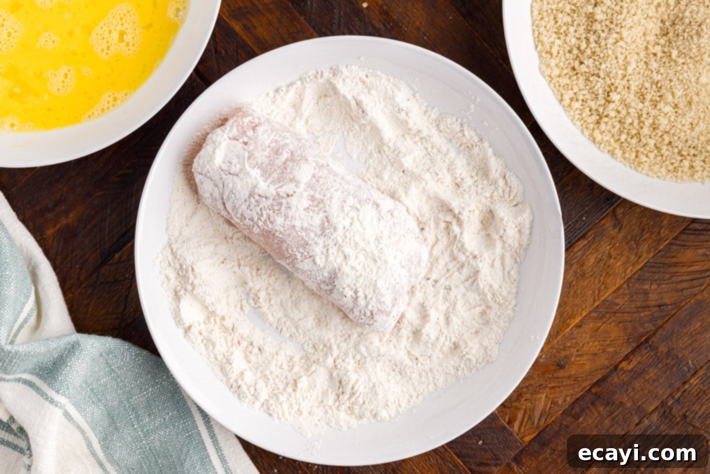 Gourmet Stuffed Chicken Rolls 9 Dredging a rolled chicken breast in seasoned flour mixture, ensuring an even coat