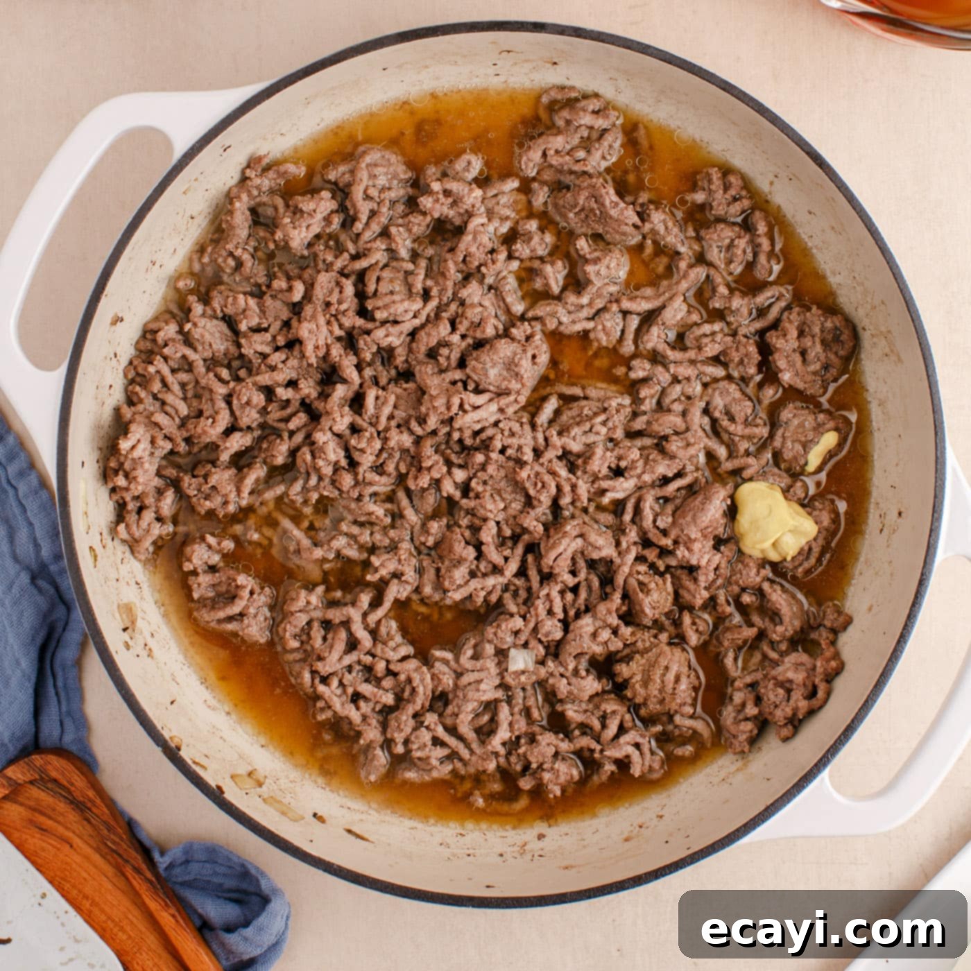 Creamy Ground Beef Stroganoff 7 Cooked ground beef in a skillet with beef broth, Worcestershire sauce, and Dijon mustard.
