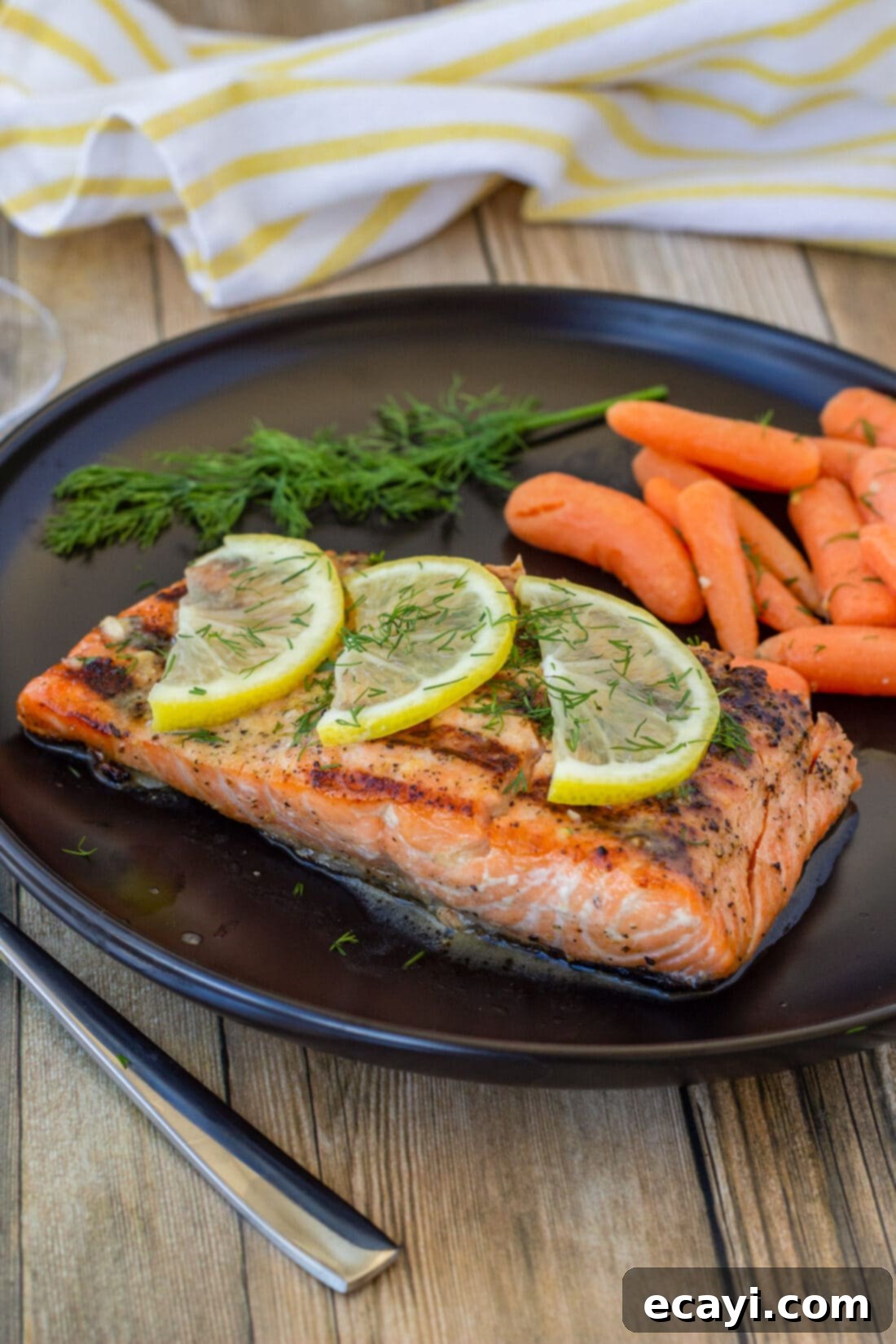 Lemony Salmon 2 Perfectly grilled lemon salmon served with vibrant roasted carrots on a plate, showcasing its golden crust and juicy interior.