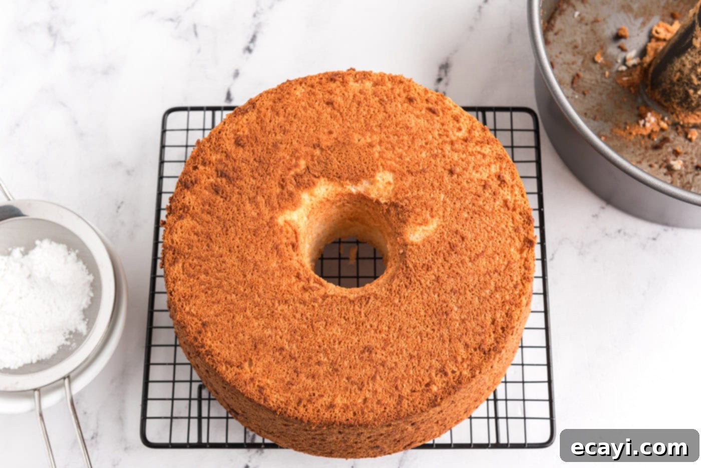 Heavenly Homemade Angel Food Cake 13 Baked angel food cake cooling on a wire rack after being removed from the pan
