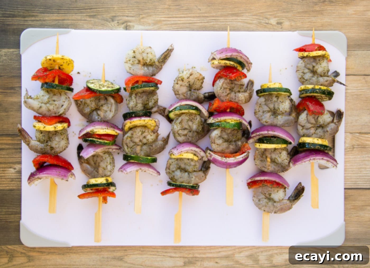 Garlic Herb Shrimp Skewers 9 shrimp kabobs with fresh veggies on a cutting board