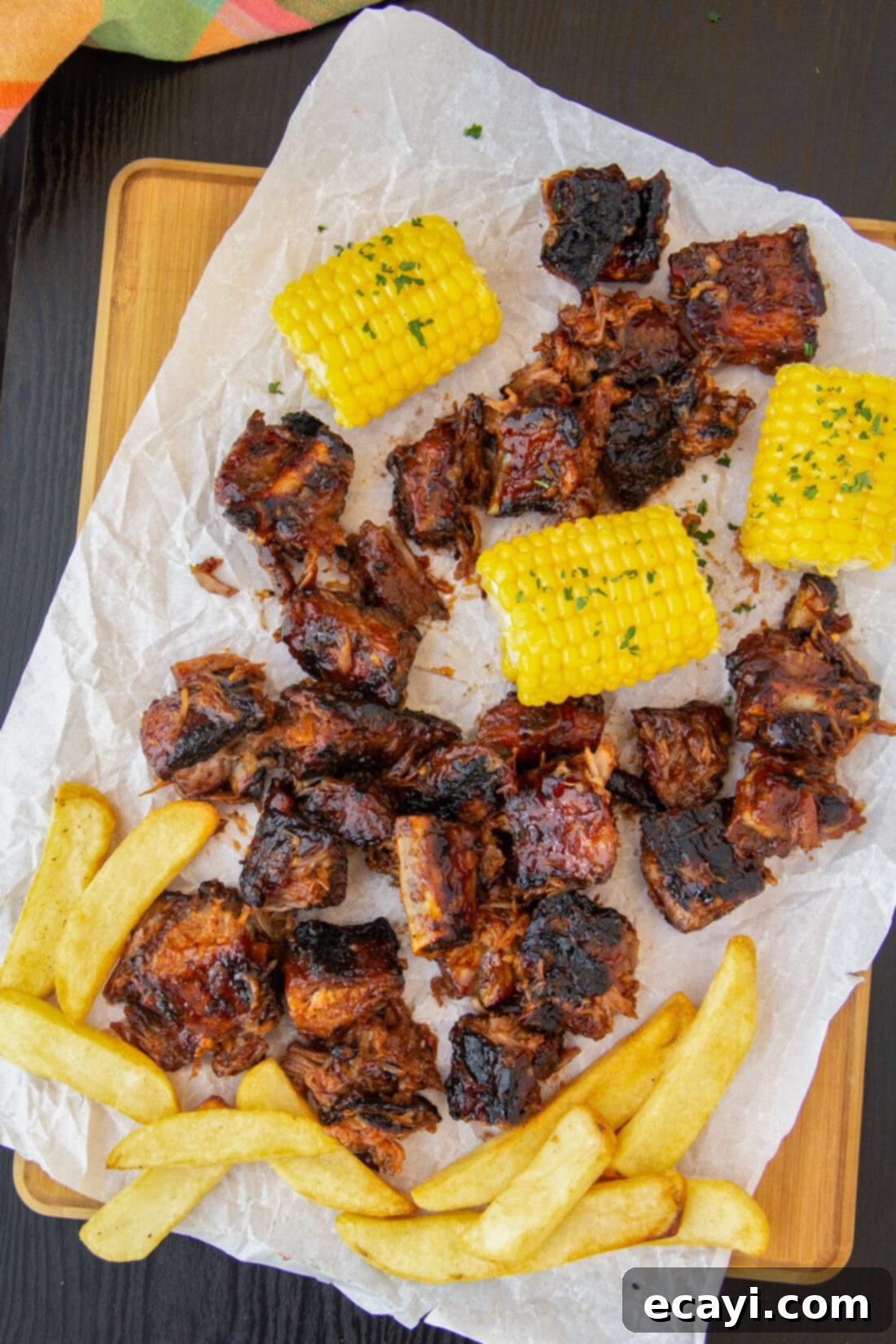 Smoked Rib Ends 2 Tender Rib Tips with crispy fries and grilled corn on a rustic cutting board, ready to be enjoyed.