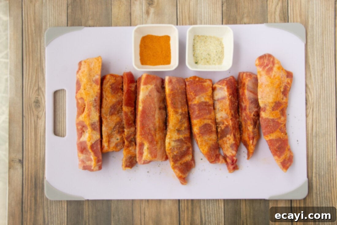 Smoked Rib Ends 4 All the simple ingredients for making rib tips, including pork rib tips, seasoning salts, and barbecue sauce, laid out on a clean surface.