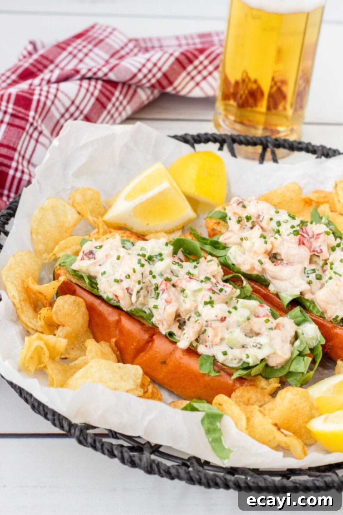 Signature Lobster Roll 3 Two deliciously prepared lobster rolls nestled in a serving basket alongside crunchy potato chips, ready to be enjoyed.