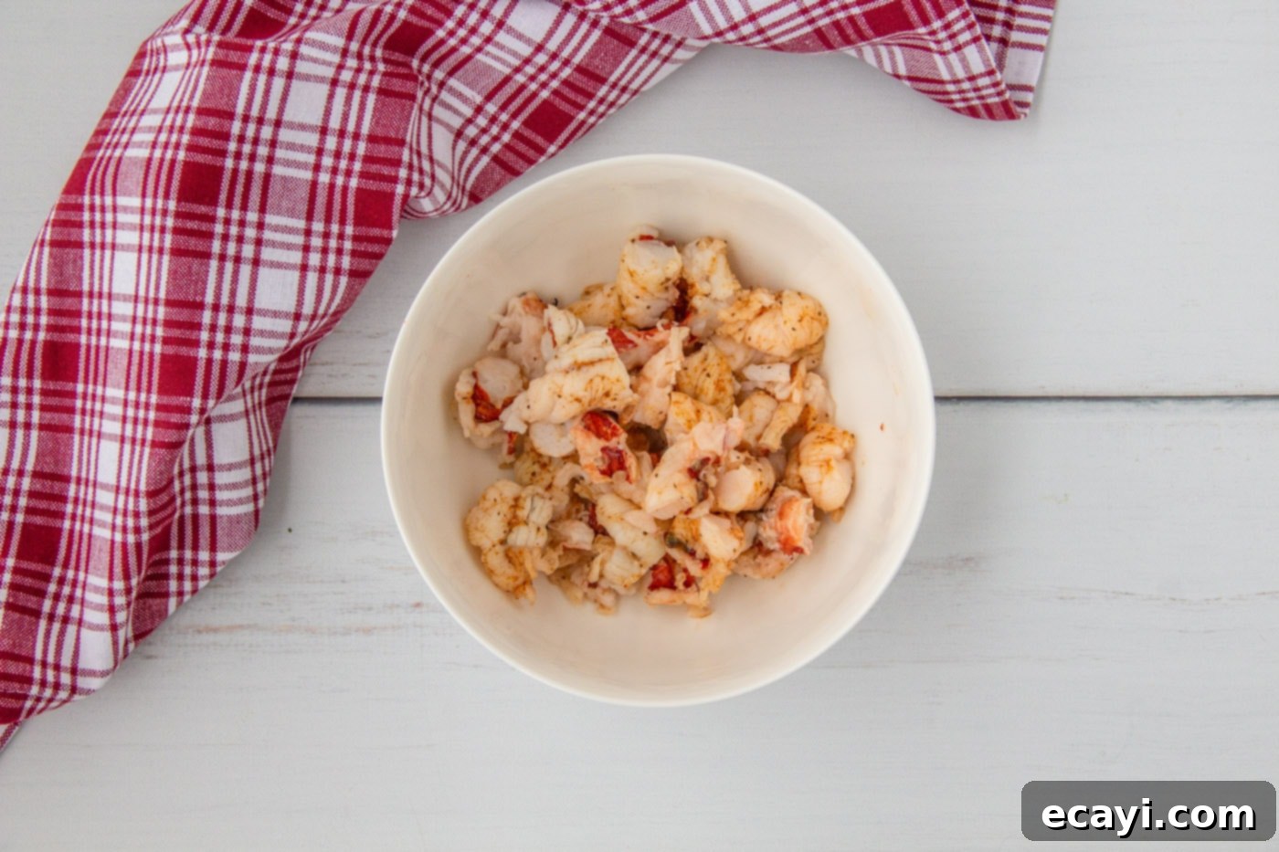 Signature Lobster Roll 8 Finely chopped lobster tail meat neatly placed in a mixing bowl, ready for the next step of the recipe.