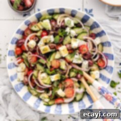 Authentic Greek Salad 9 Bowl of Greek Salad with serving spoons in it