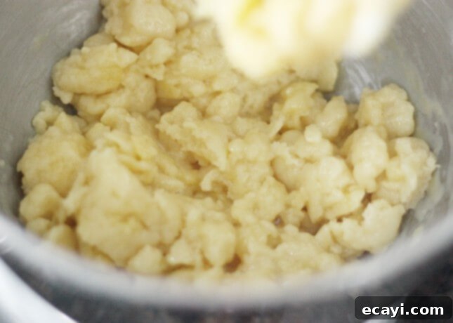 Chocolate Eclairs A Visual Step by Step Guide 17 Choux dough appearance after adding an egg, looking curdled before fully incorporating // FoodNouveau.com