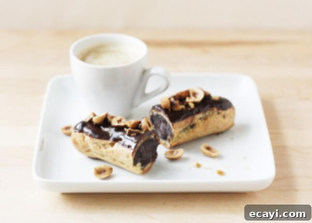 Chocolate Eclairs A Visual Step by Step Guide 8 A perfectly baked chocolate éclair topped with crunchy toasted hazelnuts // FoodNouveau.com
