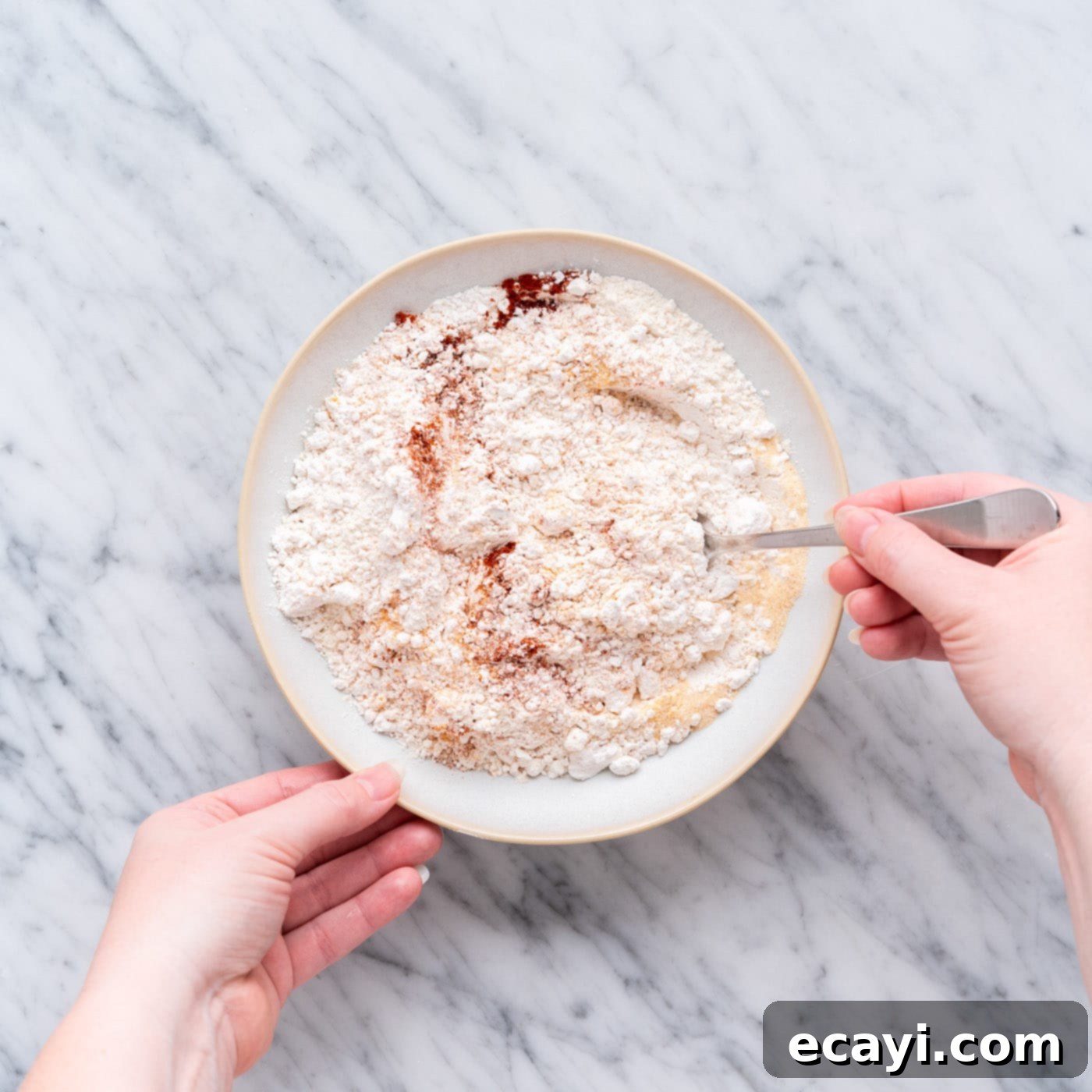 Crispy Air Fryer Chicken 7 mixing seasoned flour in a shallow bowl