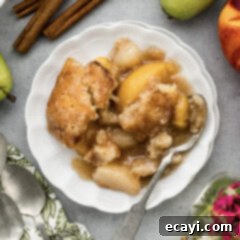 Golden Pear Peach Cobbler 15 Close up photo of a plate of Pear-Peach Cobbler topped with a scoop of ice cream
