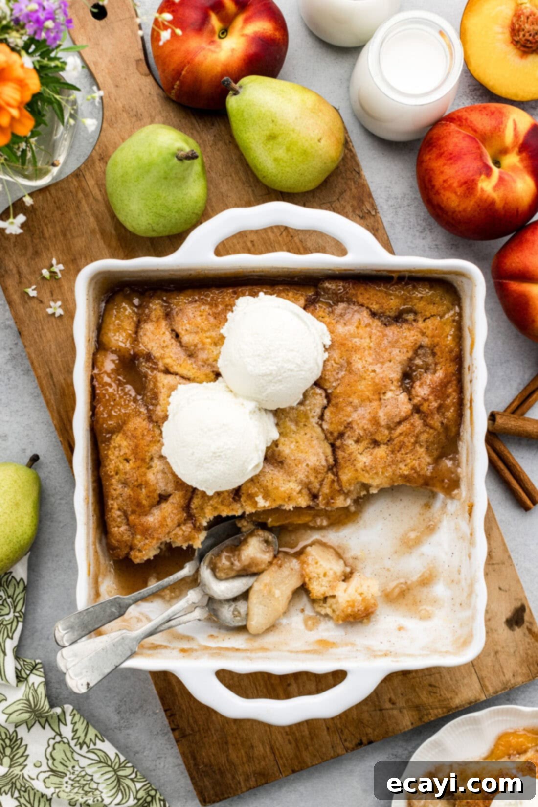 Golden Pear Peach Cobbler 3 Baking dish of Pear-Peach Cobbler topped with two scoops of ice cream