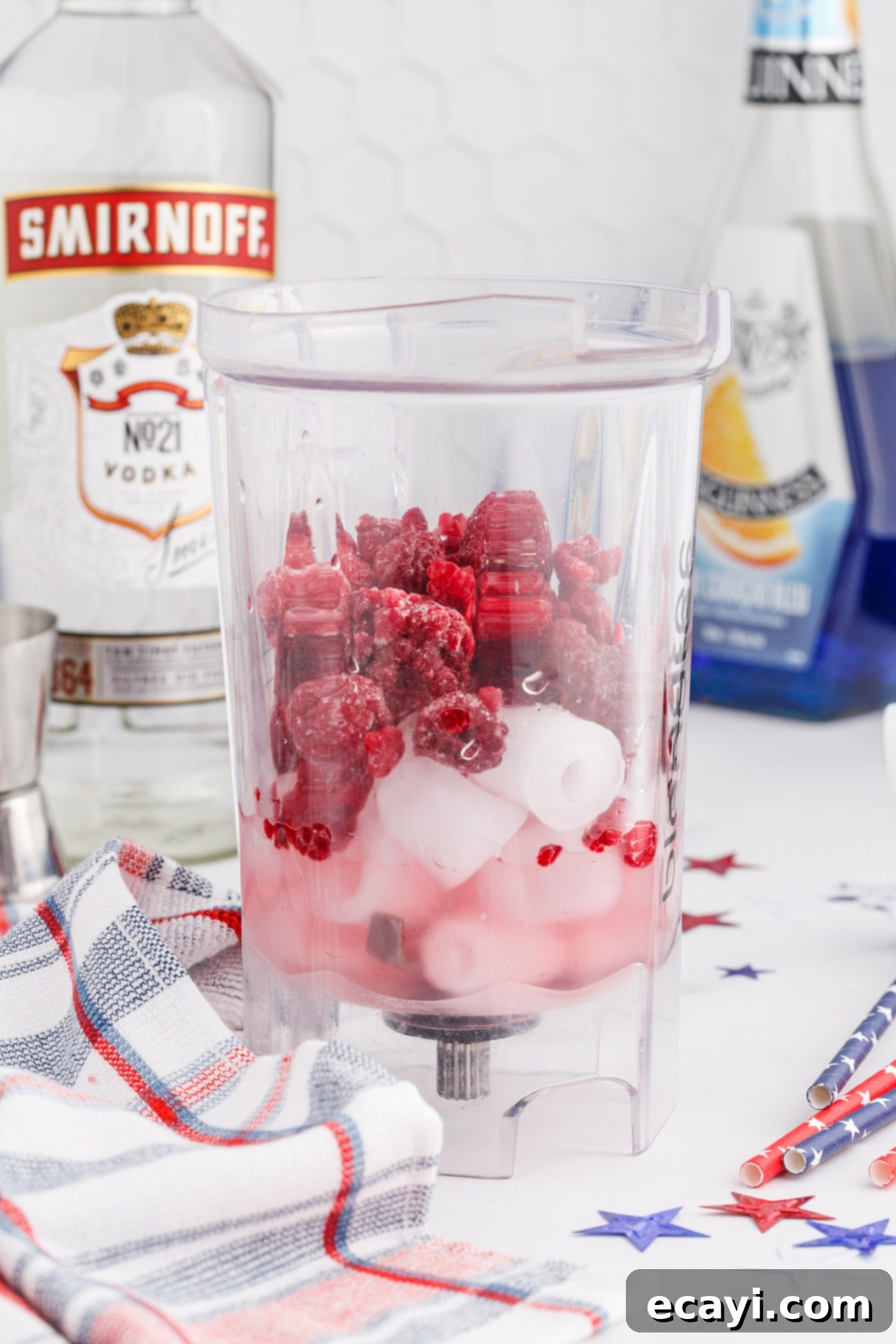 Red White & Boozy Freeze 5 Frozen raspberries, lemonade, ice, and vodka are added to a blender for the red layer of the slushie.