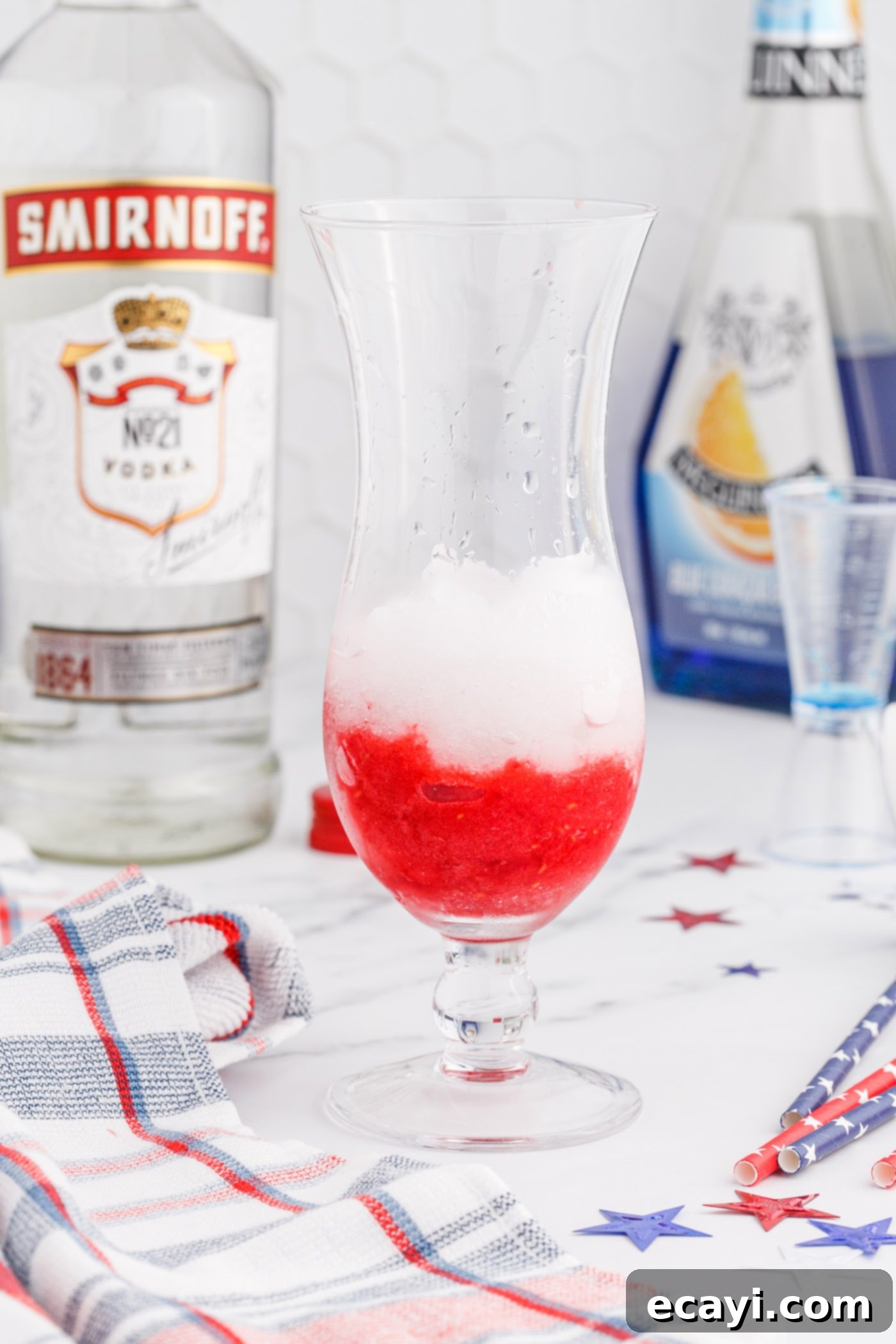 Red White & Boozy Freeze 9 The red raspberry slush layer being spooned into the bottom of a glass, followed by the white lemonade layer.