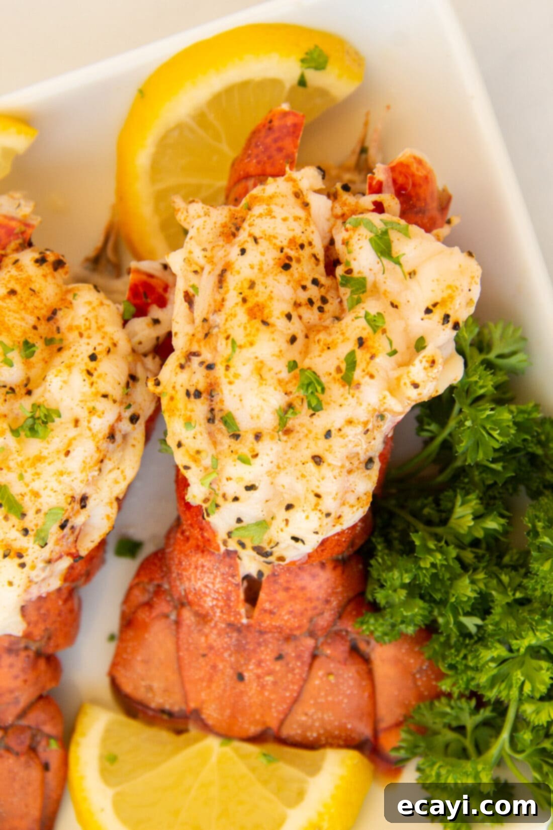 Succulent Steamed Lobster Tail 2 Exquisite Steamed Lobster Tail garnished with parsley and lemon on a plate, highlighting tender, juicy meat.