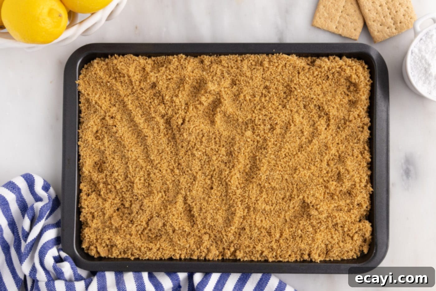 Golden Lemon Indulgence 7 Toasted graham cracker crumbs cooling on a baking sheet after being removed from the oven.
