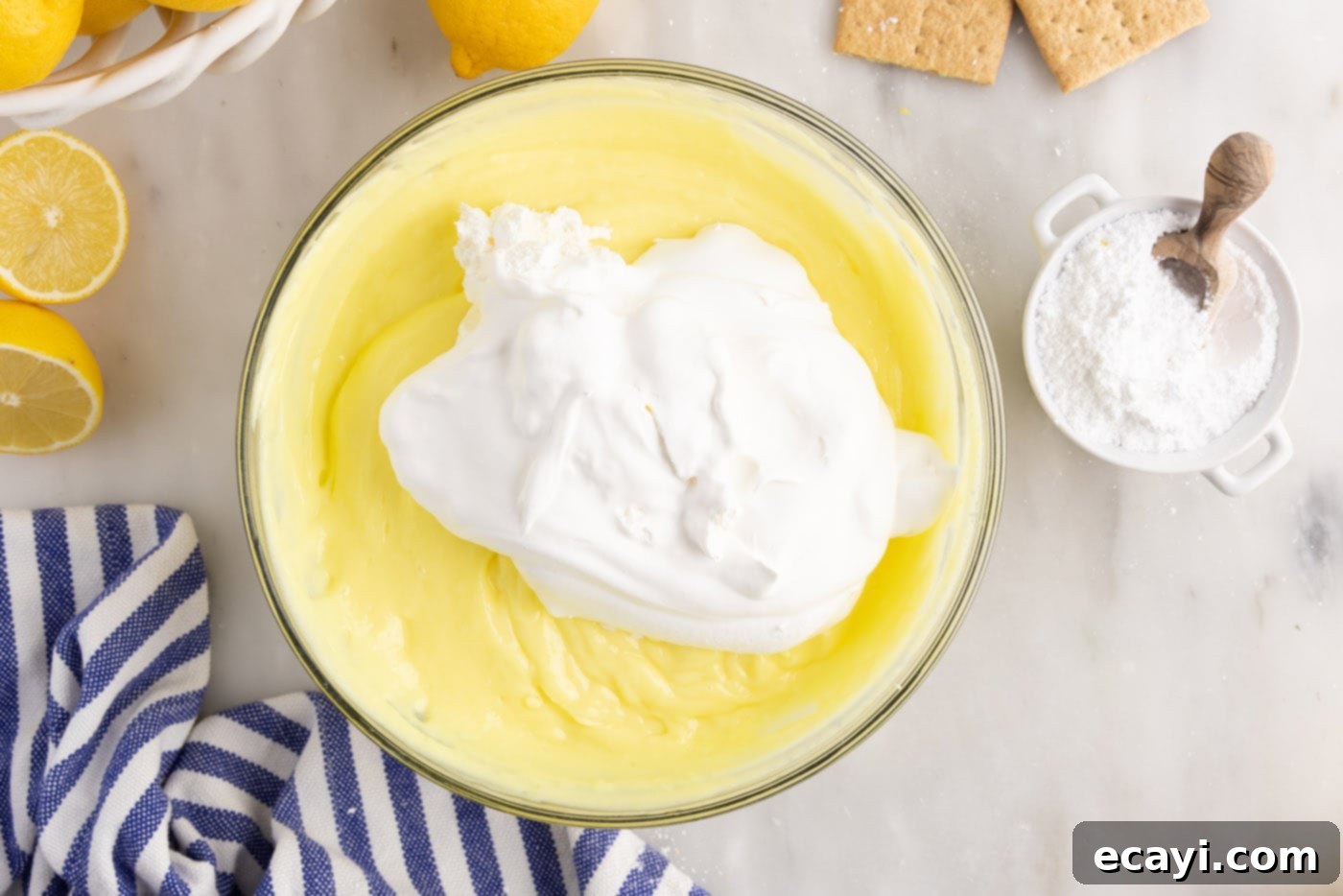 Golden Lemon Indulgence 8 Cool Whip being folded into thickened lemon pudding mixture.