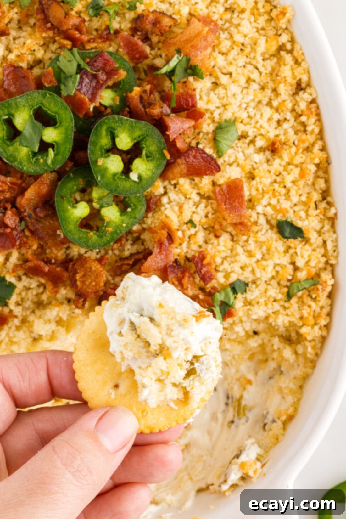 Zesty Jalapeno Delight Dip 2 hand lifting chip from Jalapeno Popper Dip