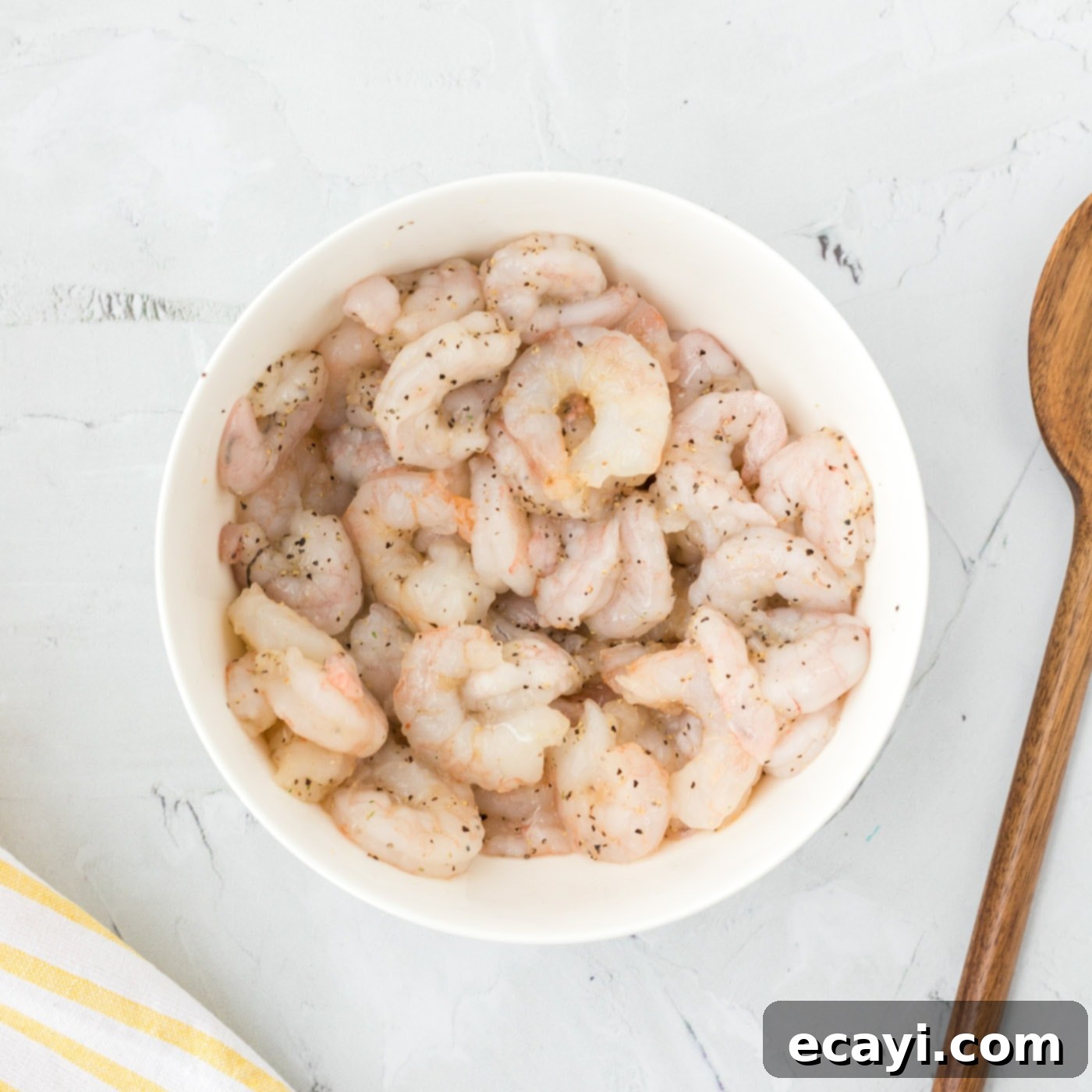 Zesty Shrimp Salad 5 seasoned uncooked shrimp in a bowl, ready for cooking with black pepper and garlic salt