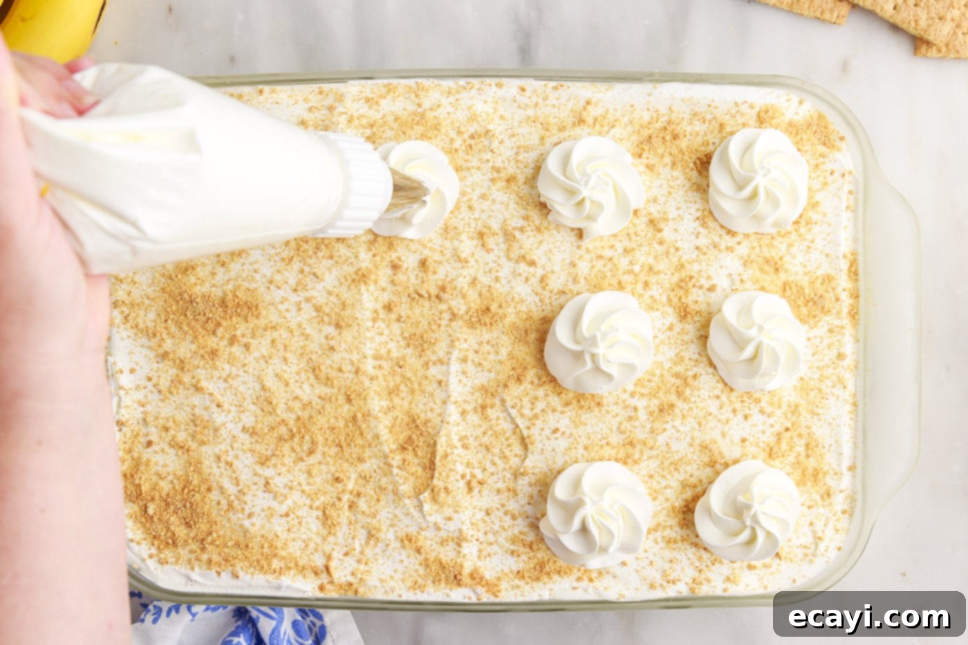 No-Bake Banana Cream Delight 14 piping whipped cream on top of banana cream pie icebox cake