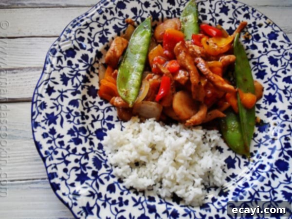 Peppered Pork Stir Fry with Sweet Peppers - AmandasCookin.com An overhead photo of a plate of peppered pork stir fry with sweet peppers with rice on the side.