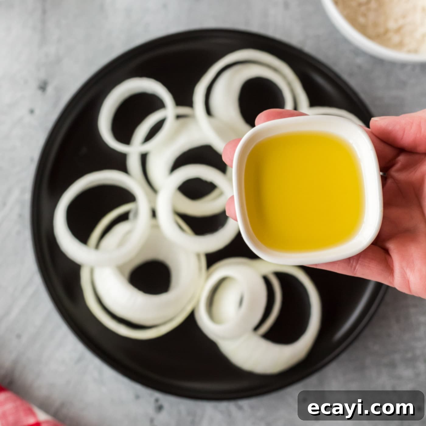 Golden Onion Crisps 5 Onion rings being tossed with olive oil in a mixing bowl