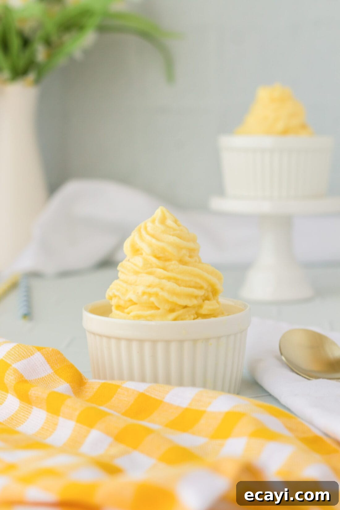 Pineapple Paradise Swirl 2 A dish of perfectly piped homemade Dole Whip, with another serving blurred in the background, ready to be enjoyed.