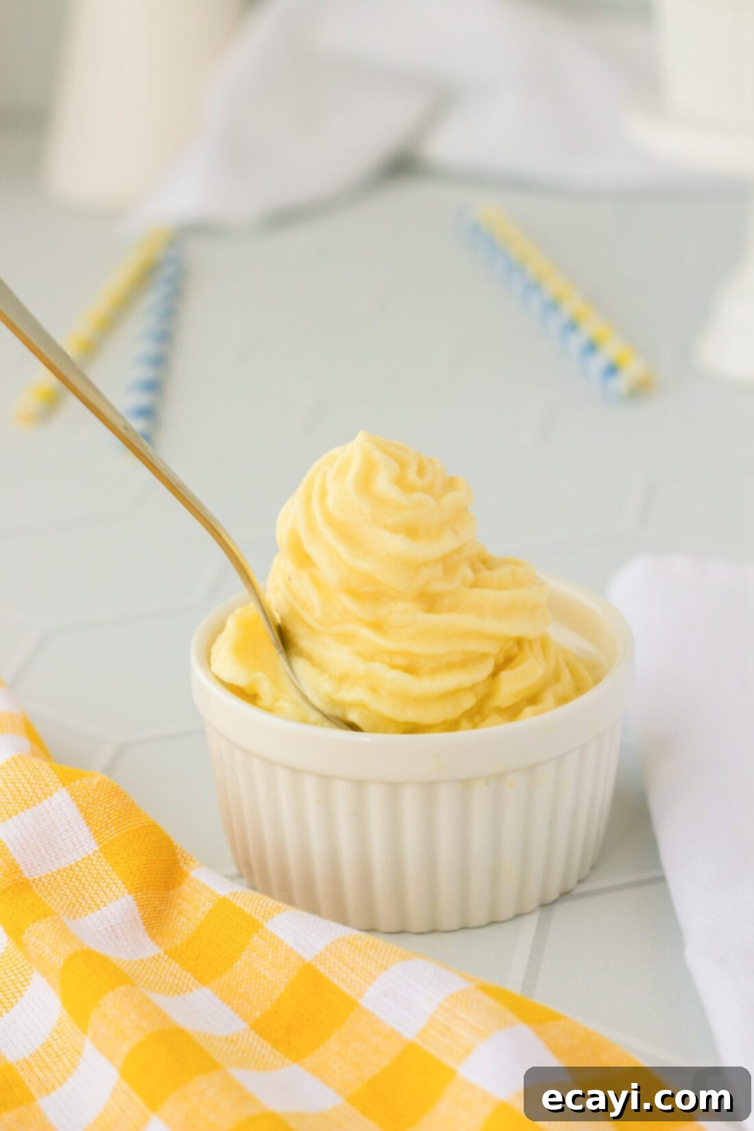 Pineapple Paradise Swirl 3 A close-up shot of a spoon digging into a refreshing dish of homemade Dole Whip, highlighting its smooth, creamy texture.