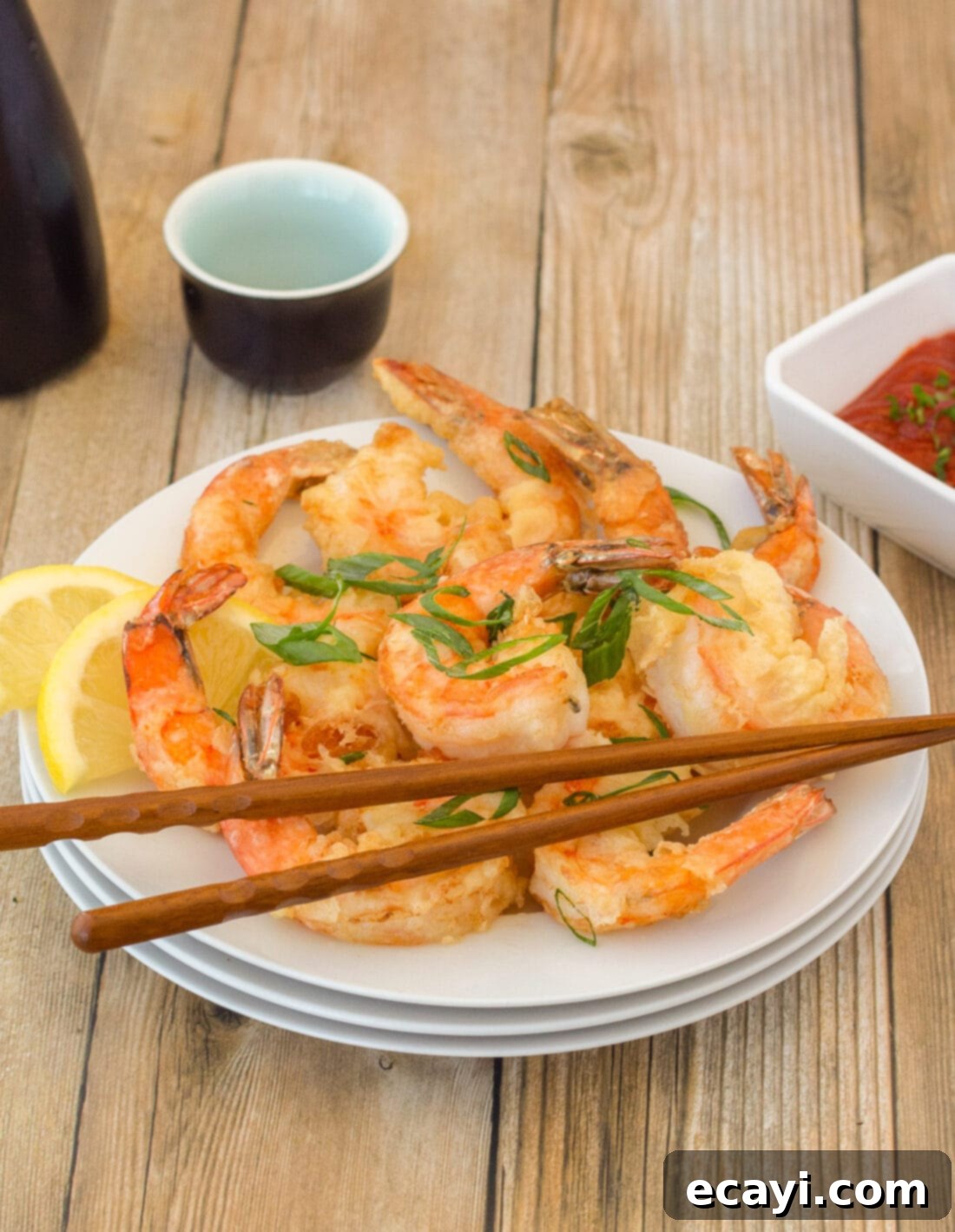 Golden Crispy Shrimp 2 Plate of perfectly golden crispy shrimp with chopsticks, ready to be enjoyed as a main course or appetizer.