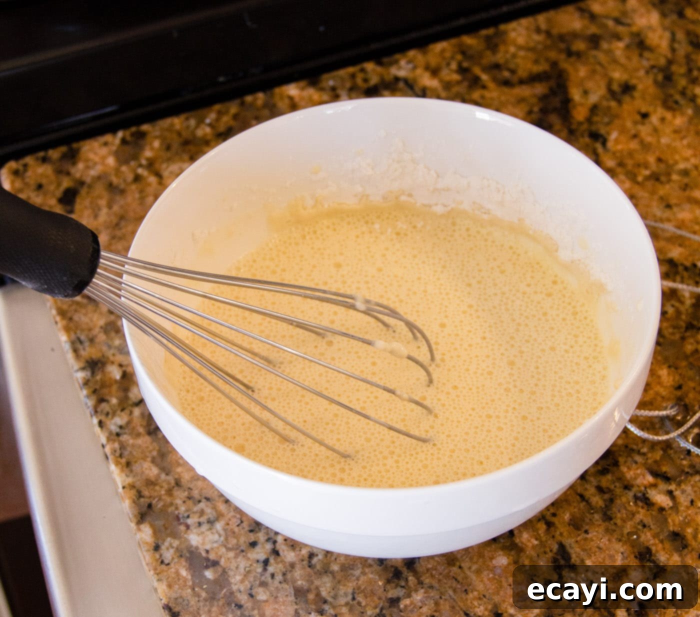 Golden Crispy Shrimp 7 Whisking an egg, all-purpose flour, and iced water together in a medium bowl to create a smooth, lump-free batter for the shrimp.
