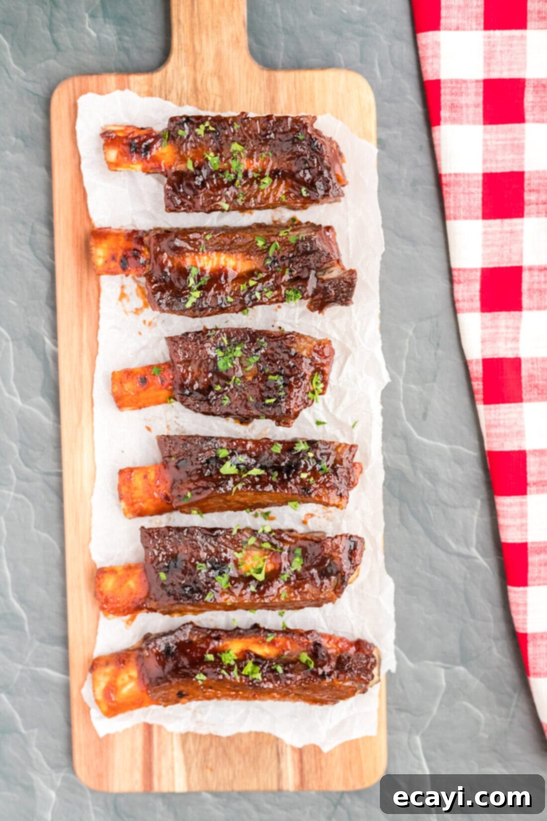 Effortless Instant Pot Beef Ribs 2 Instant Pot Beef Ribs on a long cutting board, perfectly cooked and ready to serve.