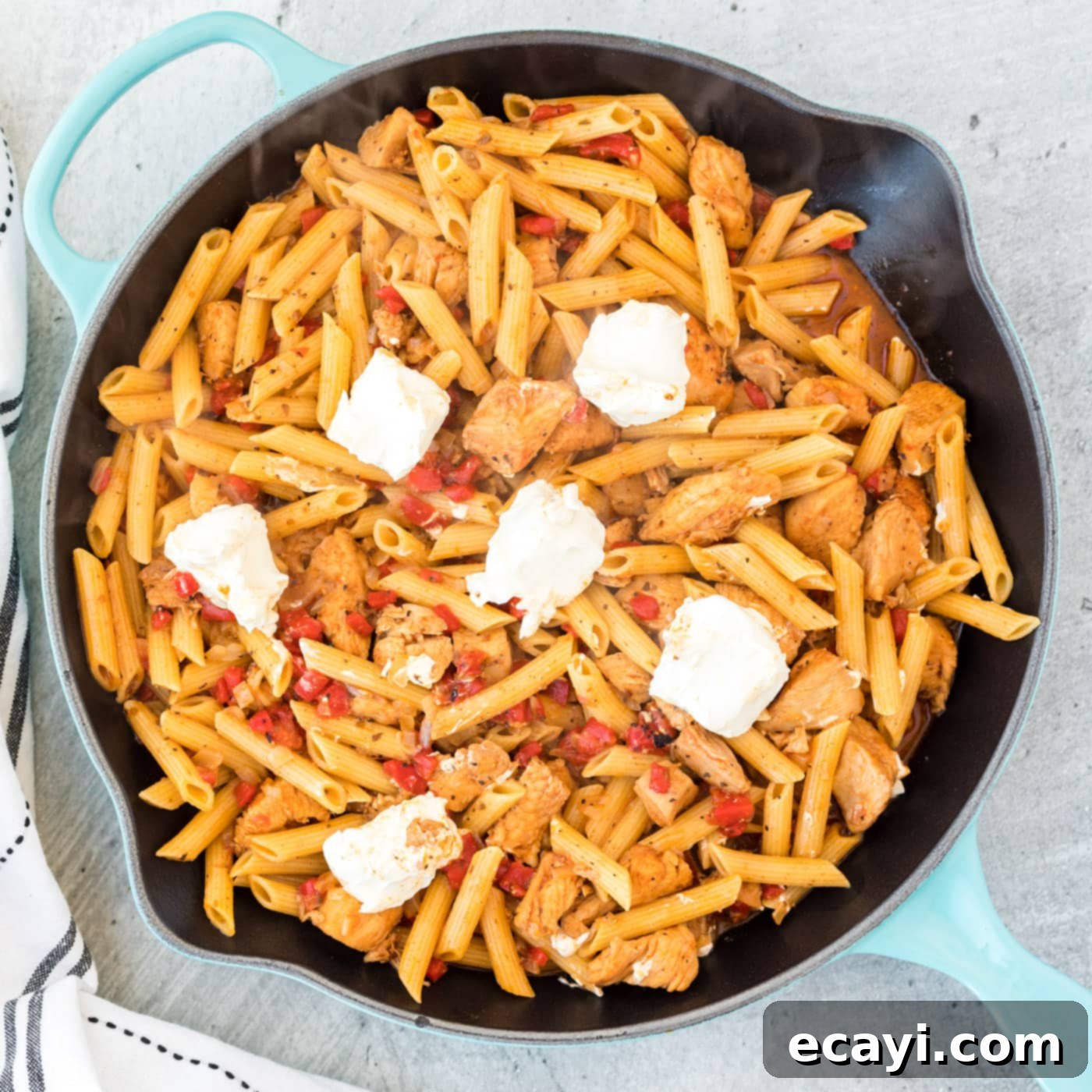 Spicy Cajun Chicken Pasta 7 Cajun chicken pasta in a skillet with cream cheese melting on top, prior to stirring.