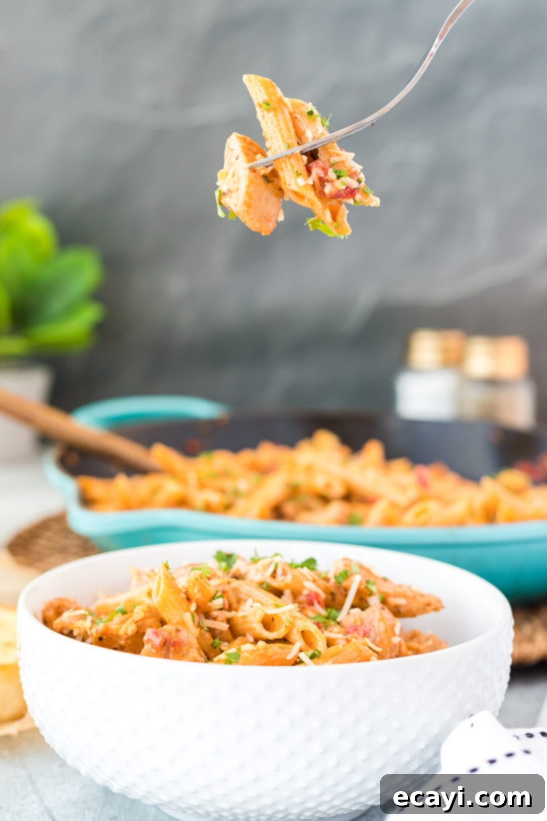 Spicy Cajun Chicken Pasta 8 A fork lifting a mouthful of creamy Cajun Chicken Pasta from a bowl.