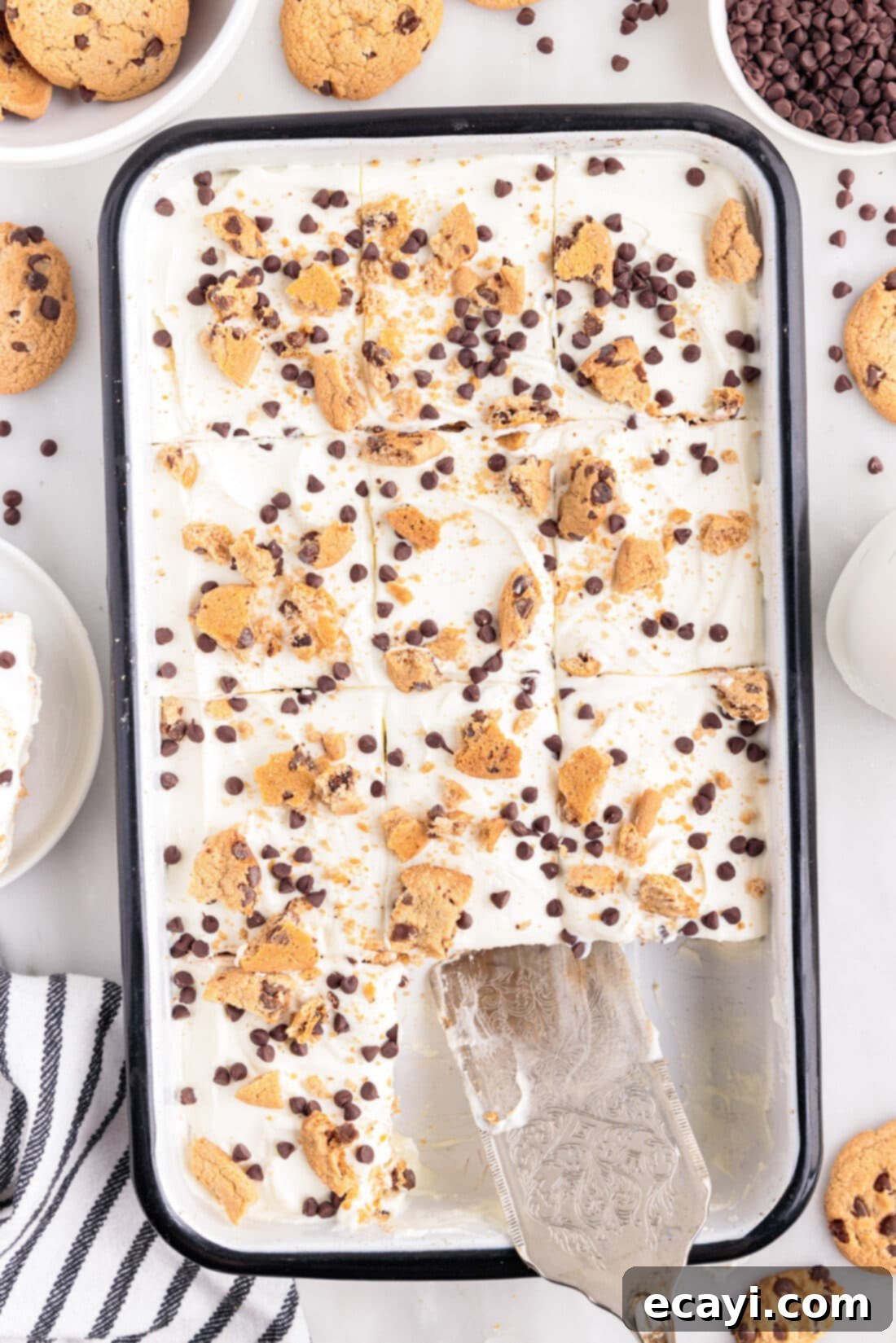 No-Bake Chocolate Chip Cookie Dream Cake 3 A casserole dish filled with an un-sliced Chocolate Chip Cookie Icebox Cake, with a serving spatula resting inside, ready to be served.