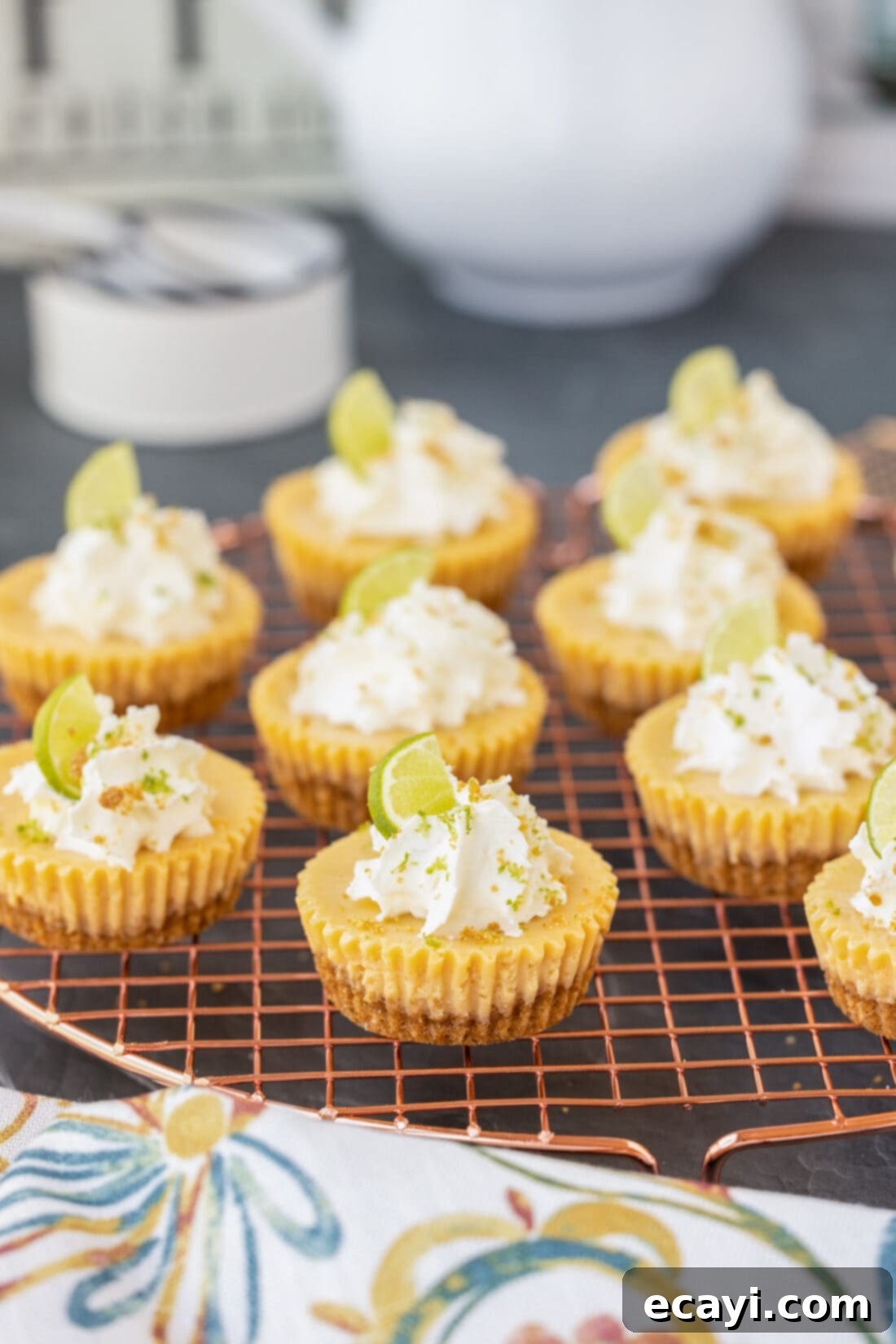 Key Lime Pie Bites 2 Mini Key Lime Pies on a wire rack, showcasing their vibrant lime color and golden crust.