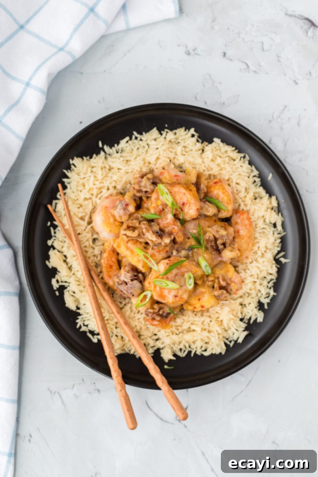 Candied Honey Walnut Shrimp 10 A beautifully presented plate of Honey Walnut Shrimp with rice and chopsticks, ready to be enjoyed