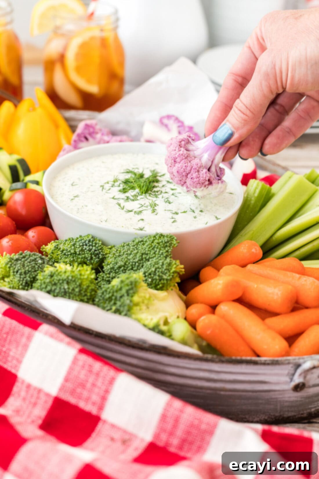 Creamy Dill Dream 3 A hand dipping a fresh piece of cauliflower into the creamy dill dip, showcasing its perfect consistency.