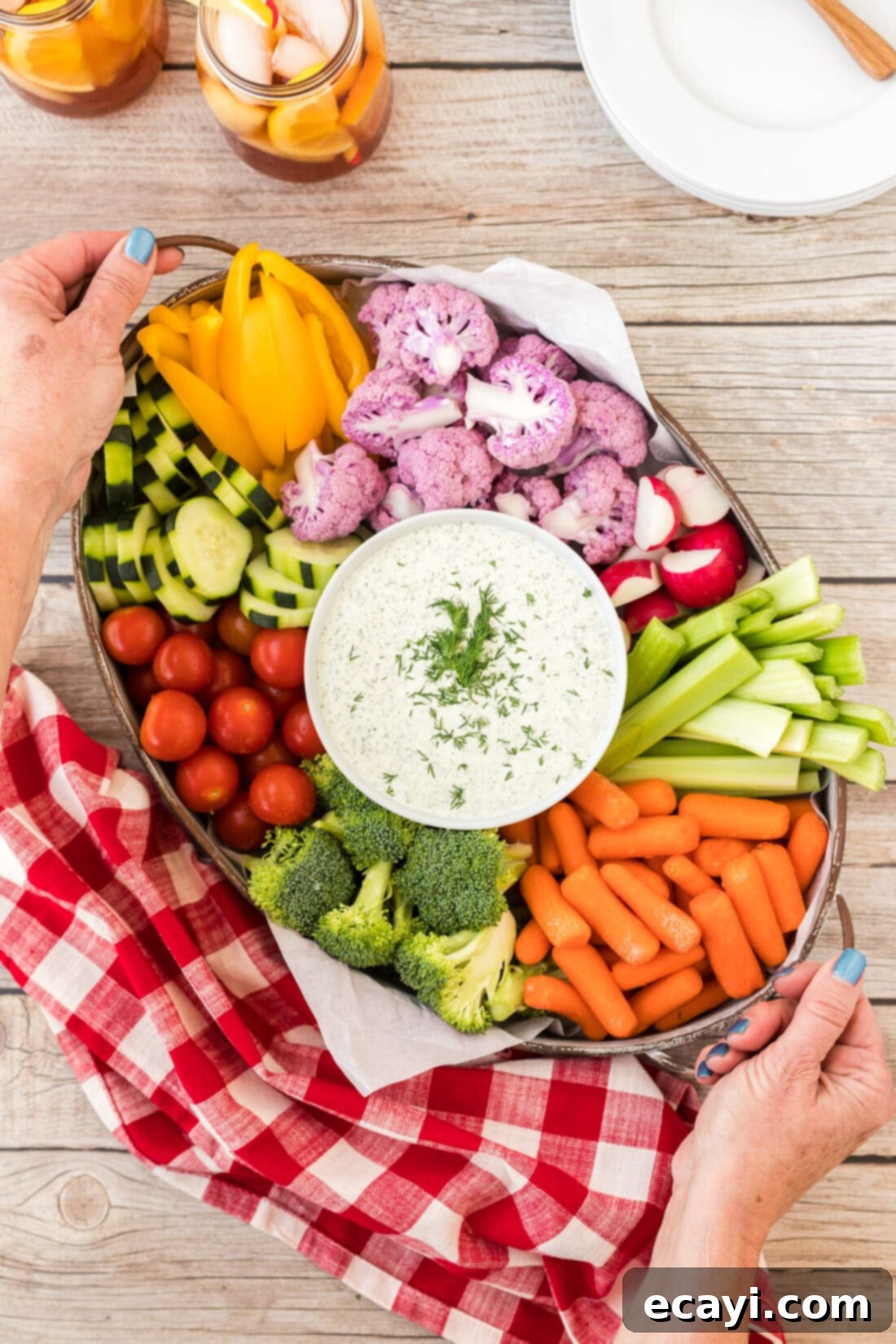 Creamy Dill Dream 7 A festive tray of dill dip surrounded by an assortment of fresh vegetables and salty snacks, ready for a party.